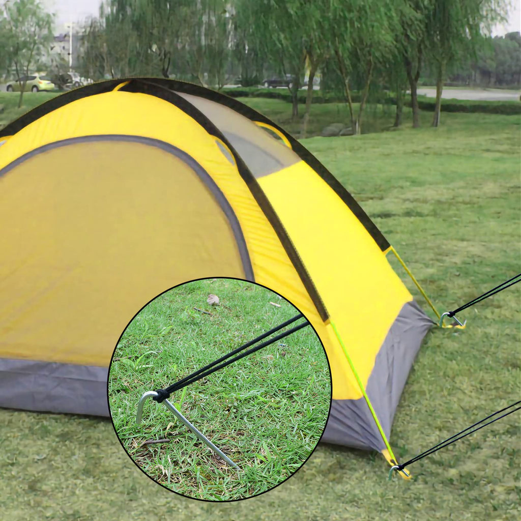 Securing a canopy leg to the ground using a 9-inch metal tent stake in sandy soil at a campsite